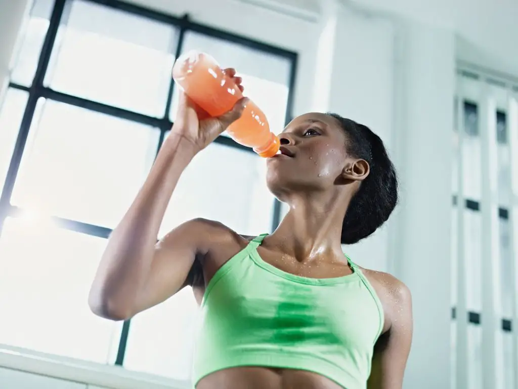 african woman in gym drinking energy drinkAfrican Woman In Gym Drinking Energy Drink