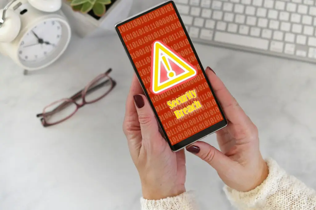 Female holding a phone with Security Breach warning screen in red and yellow