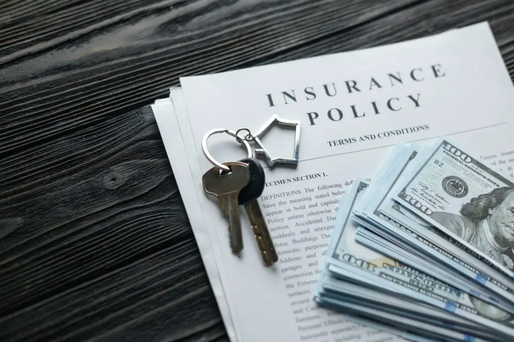 Home insurance policy with keys and dollar money mortgage, loan or home insurance documents