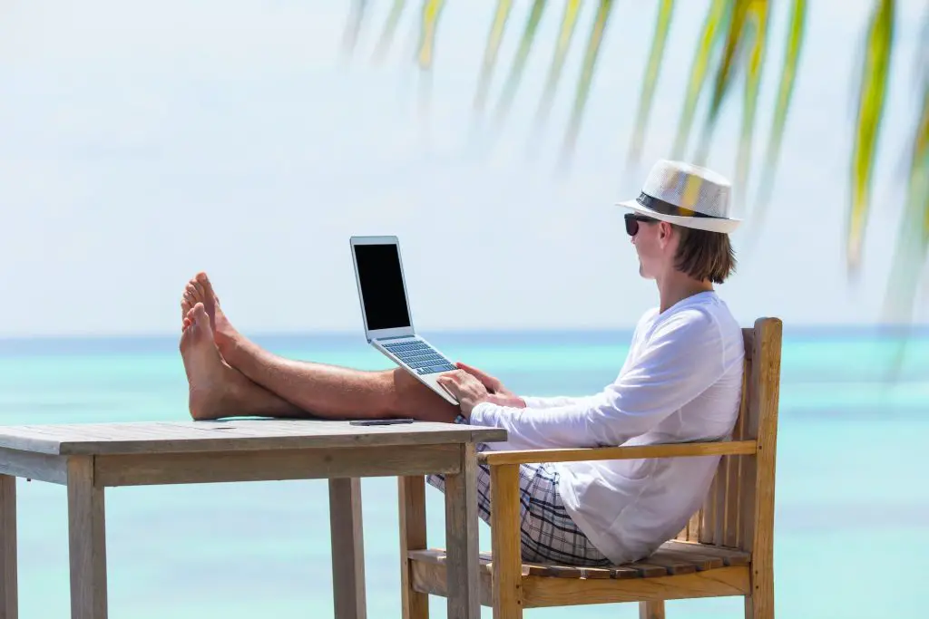 Young man working on laptop during summer vacation